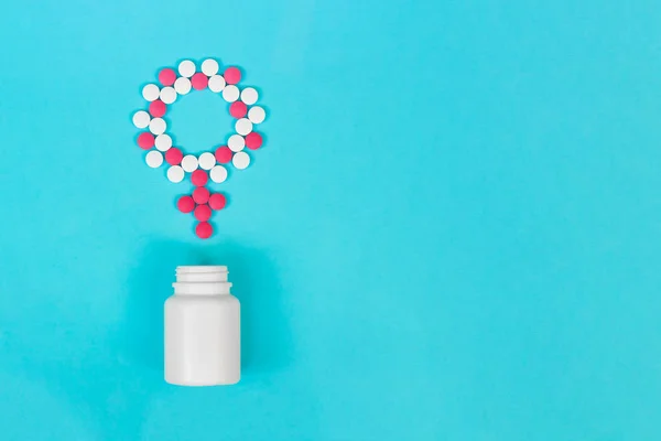 Konzept weibliche Gesundheit, weibliche Verhütung. Venus Geschlechtssymbol aus rosa und weißen Pillen mit der Flasche auf hellblauem Hintergrund. Kopierraum — Stockfoto