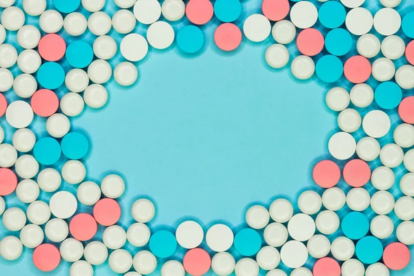 Круглая рамка из белых, синих и красных таблеток на голубом фоне — стоковое фото