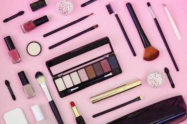 Makyaj fırçası ve dekoratif kozmetik açık pembe arka plan üzerinde. Üstte görüntü