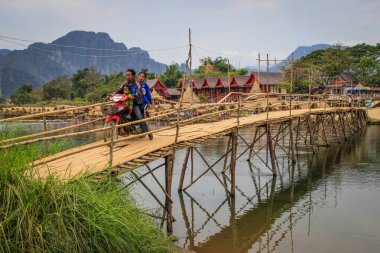 Vang Vieng, Laos - 1 Mart 2016: kişi ahşap köprü arası Mekong Nehri Vang Vieng Köyü