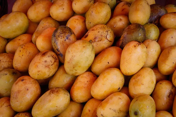 Ripe and juicy yellow mangoes are on the market counter