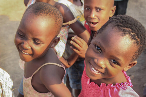 Fort Portal, Uganda - January 27, 2015: African village children playing near the lake shore in the suburb of Fort Portal