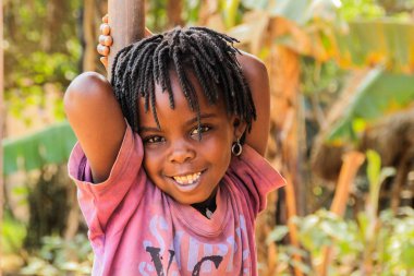 Kampala, Uganda - 26 Ocak 2018: Dreadlocks gülümsüyor Kampala banliyö sokakta oynarken çok şirin Uganda Afrika kızla