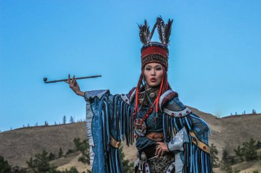 Kızıl, Tuva, Rusya - 10 Ağustos 2014: Şaman ve cadı kostüm mongol kadın dans ediyor ve bir boru dağlar çerçevede dumanlar
