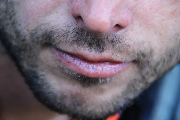 Beautiful thin men\'s lips and light unshaven face close up