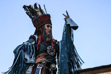 Kızıl, Tuva, Rusya - 10 Ağustos 2014: Moğol kadında şaman ve cadı kostüm dansları sahnede dağlarda. Tuva Halk oyunları