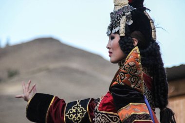 Kızıl, Tuva, Rusya - 10 Ağustos 2014: Moğol kadında şaman ve cadı kostüm dansları sahnede dağlarda. Tuva Halk oyunları