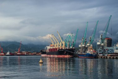 Batum, Gürcistan - 21 Temmuz 2014: Şehir bağlantı noktası ile kargo gemileri, mavna ve gün batımında Vinçler.