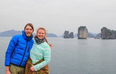 Genç adam ve kız sarılma ve mutlulukla Vietnam'da balayı sırasında uçuruma Ha uzun koyu arka planı gülüyor spor giyim, Çift