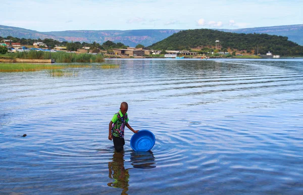 赞比亚姆普隆古 2015年3月23日 一名黑人男孩在坦噶尼喀湖的蓝色盆地中打水 — 图库照片