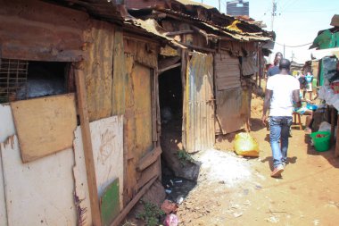 Kibera, Nairobi, Kenya - February 13, 2015: a street in slums with poor huts clipart