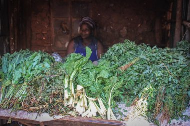 Kibera, Nairobi, Kenya - 13 Şubat 2015: Yeşiller üstünde belgili tanımlık sayaç Afrika yoksul şehirlerinden birinde satış Afrikalı kadın