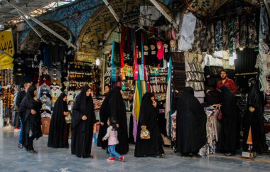 Kum, Iran - 10 Mayıs 2017: Ünlü İran pazarı (bazaar) ve siyah chodor kadınlarda ürünler seçin