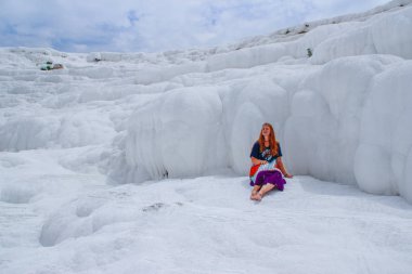Ünlü ve şaşırtıcı termal Pamukkale veya pamuk Kalesi Türkiye'de Denizli ilinde üzerinde yaylar. Parlak elbiseli kızıl saçlı hippi kız