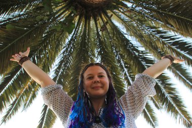 Mavi kuyruklu beyaz kızla ve palmiye ağaçları arka plan üzerinde ellerini dalgaları