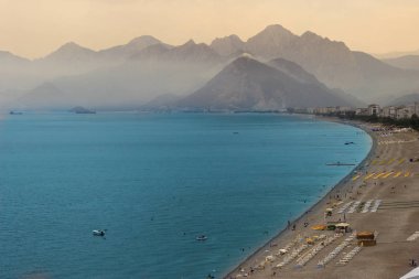 Antalya, Türkiye - 10 Haziran 2017: Kayalı, dağlarla ve berrak turkuaz sularla dolu plaj. Türk cenneti.