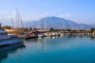 Demre, Türkiye - 12 Haziran 2017: Berrak turkuaz suile aydınlık bir yaz güneşli gününde yat ve teknelerle liman.
