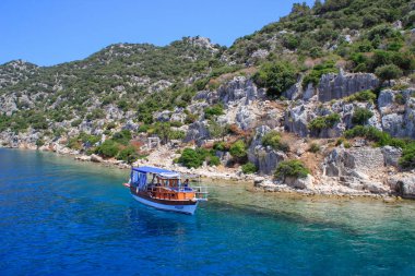 Bodrum, Türkiye - 16 Haziran 2017: Akdeniz'de kayalar ve parlak turkuaz su. Antik kentin kalıntıları.