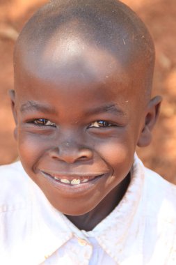 Kampala, Uganda - 27 Ocak 2015: Afrikaköy çocuğunun potraite'si gülümseyerek Kampala banliyösünde evinin yakınında oynuyor.