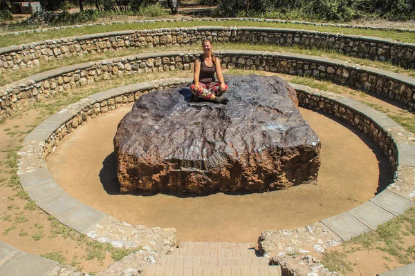 ナミビアのグロトフォンテインでは世界最大の隕石である 宇宙からの鉄の巨大な作品 隕石の上に座っている白い女の子の観光客 — ストック写真