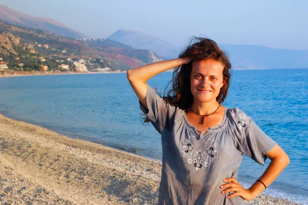 美丽的白种人年轻的黑发女子 一头长长的卷发 在地中海和阿尔巴尼亚海岸的群山的背景下 微笑着欣赏日落 — 图库照片