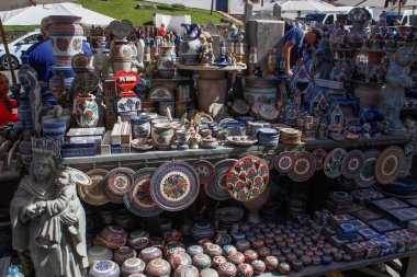 Ouro Preto, Brezilya - 3 Temmuz 2019: Şehir merkezinde bir sokak hediyelik eşya pazarı. Kilisenin yanında sabun taşı temalı tabaklar, vazolar, mıknatıslar ve heykelcikler var.