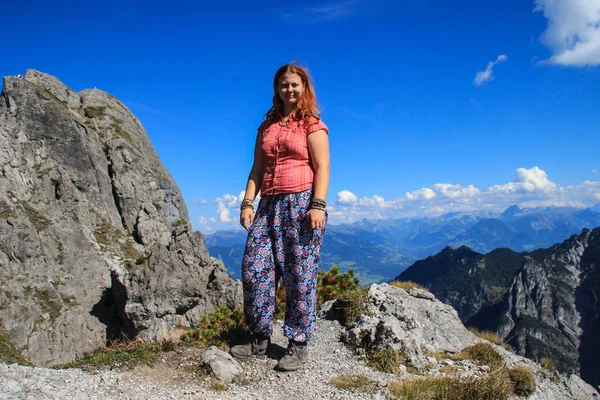 Fabulously beautiful European cozy landscape in the cozy Alps mountains in Liechtenstein on the border with Austria. Young woman tourist in the mountains.