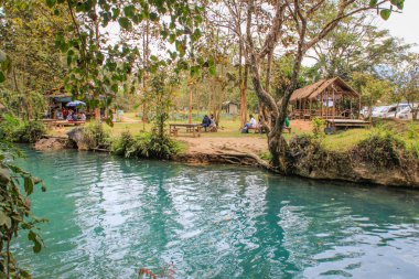 Vang Vieng, Laos - 3 Şubat 2016: Turkuaz suyu ile popüler bir tatil beldesi olan Mavi Göl, suya dalıyor ve dinlenebileceği yerler.
