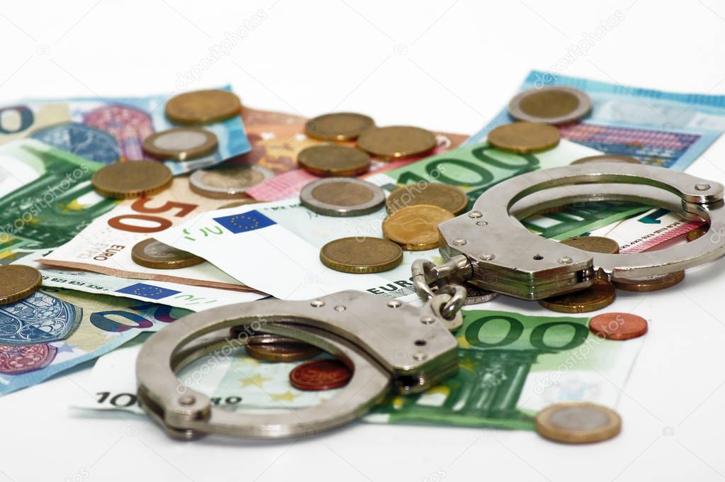 Criminal money transactions euro banknotes and handcuffs                   