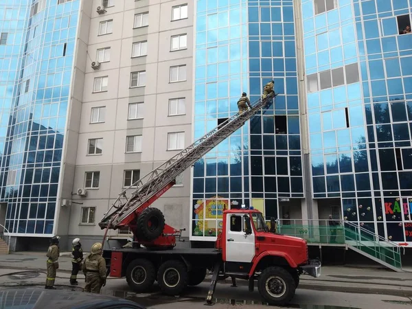 救生员从高层建筑的窗户爬上汽车的防火通道 — 图库照片