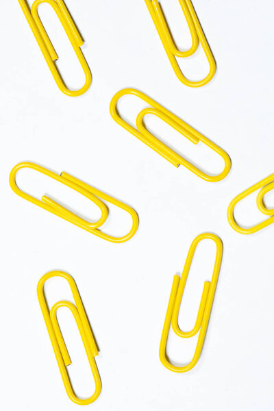 yellow office paper clips isolated on white