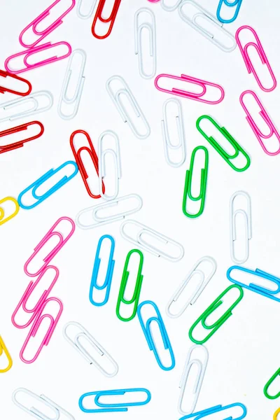 Colored office paper clips isolated on white