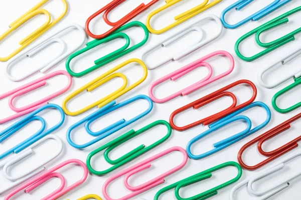 Colored office paper clips isolated on white