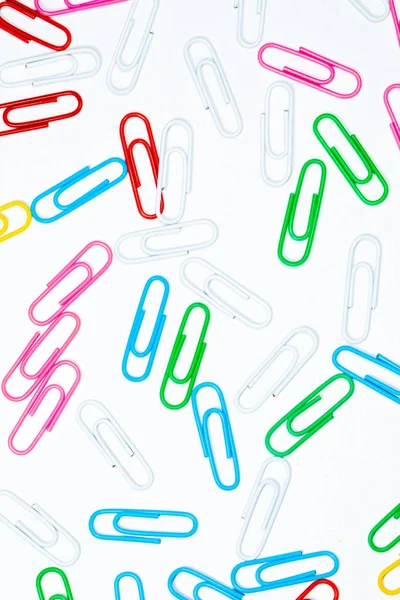 Colored office paper clips isolated on white