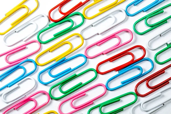 Colored office paper clips isolated on white