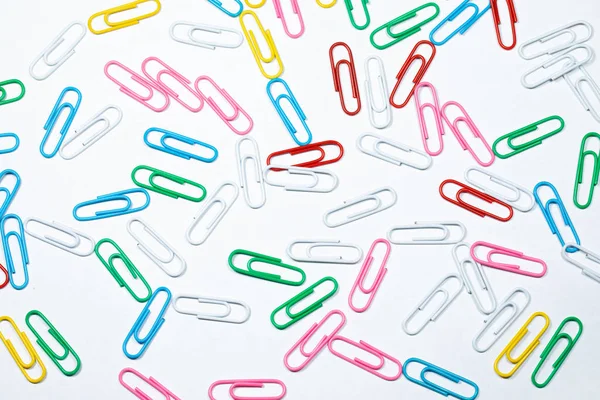 Colored office paper clips isolated on white