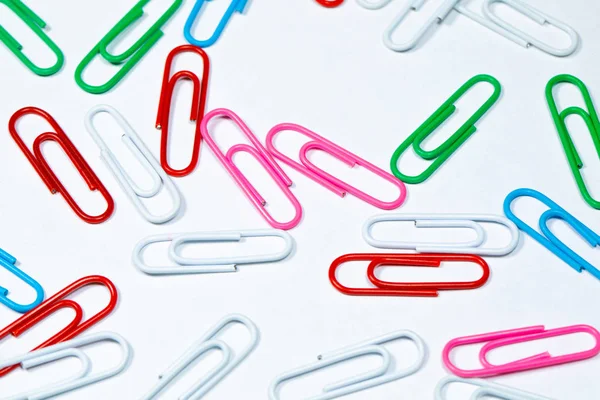 Colored office paper clips isolated on white