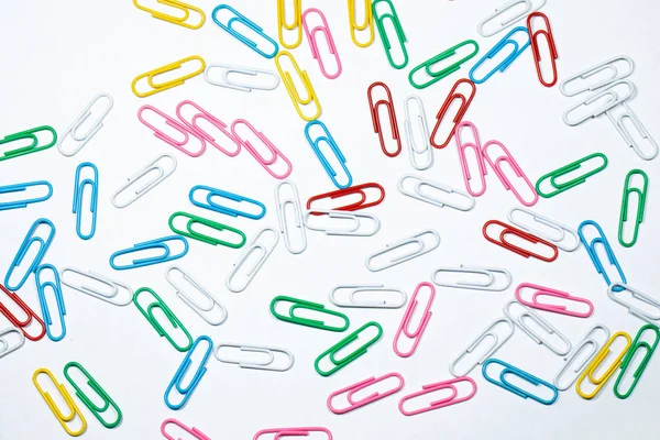 Colored office paper clips isolated on white