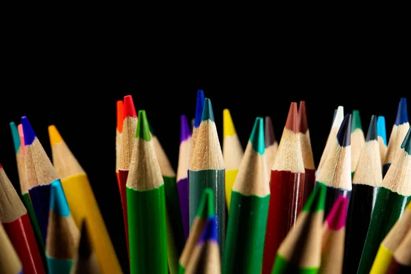 Colored sharpened pencils on black background