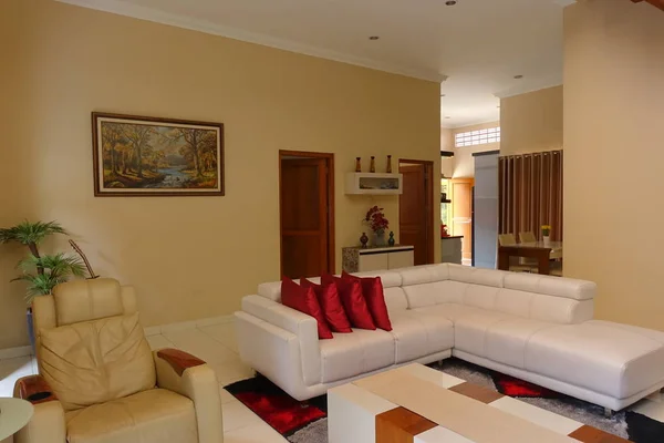 Şık salon iç modern ev tasarımı ile beyaz kanepe, kırmızı yastık ve dekorasyon. Yer: Yogyakarta, Endonezya. Şubat 2019