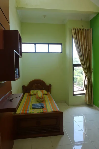 Stylish bed room interior with traditional wooden furniture; location: Yogyakarta, Indonesia