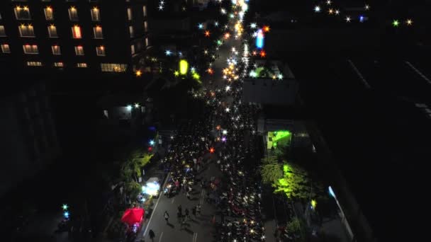 YOGYAKARTA, INDONESIA: 31 DICIEMBRE, 2018 Imágenes aéreas vista nocturna de la calle de la ciudad de Yogyakarta con multitud de personas y parque de motos — Vídeos de Stock