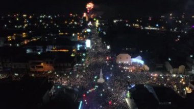 İleri insanlar kalabalık ve havai fişek gösterisi ile Yogyakarta Anıt veya Tugu Jogja manzaralı uçan hava görüntüleri dron