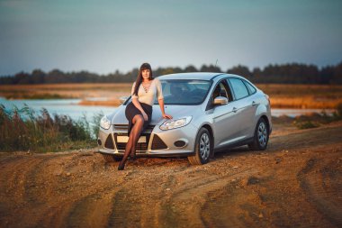 Genç mutlu güzel büyük boy modeli kız arabasını Sunset'teki yakınındaki. zor bir günden sonra istirahat iş kadını