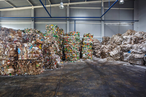Plastic pressed polyethylene bales at finished products warehouse on modern waste hazardous processing plant. Separate garbage collection. Recycling and storage of waste for further disposal. 