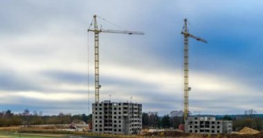 Zaman atlamalı silueti batan güneşin ışınları inşaatta çalışan bir kule vinç