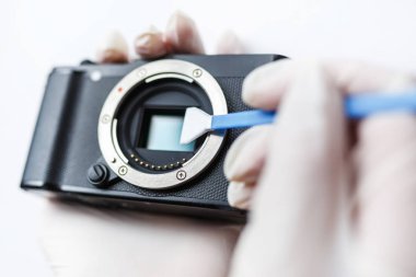 Aynasızlar dijital Aps-C kamera kirli matris sensör temizleme ve bakım bez, photocamera beyaz arka plan üzerinde temizlik fotoğrafçı ile yakın çekim