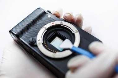 Aynasızlar dijital Aps-C kamera kirli matris sensör temizleme ve bakım bez, photocamera beyaz arka plan üzerinde temizlik fotoğrafçı ile yakın çekim