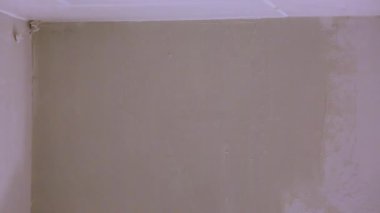 sarı eldiven spatula ile sıva veya macun beyaz duvarındaki bir delikle yama macun bıçağı tutan işçinin elinde. İç oda daire binasında tadilat tadilat ve onarım işlemi