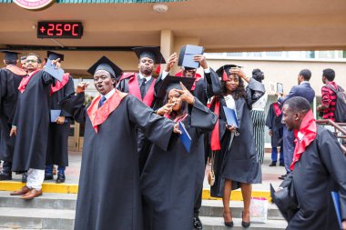 Grodno, Belarus - Haziran, 2018: Mutlu yabancı Afrika tıp öğrencileri kare akademik mezuniyet kapaklar ve bitirdikten sonra başlama diploms ile sırasında siyah trençkotlar çalışmalar